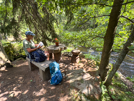 Vrouw op een bankje op de Kammweg bij een picknickplaats langs het Jöstädter Schwarzwasser